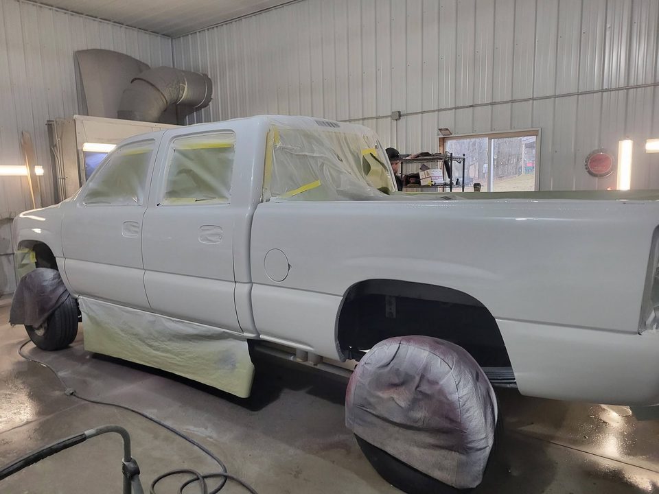 A masked pickup in the spray booth during a custom repaint