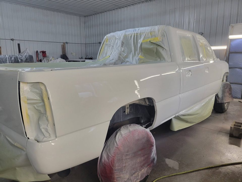 A masked vehicle inside the downdraft spray booth