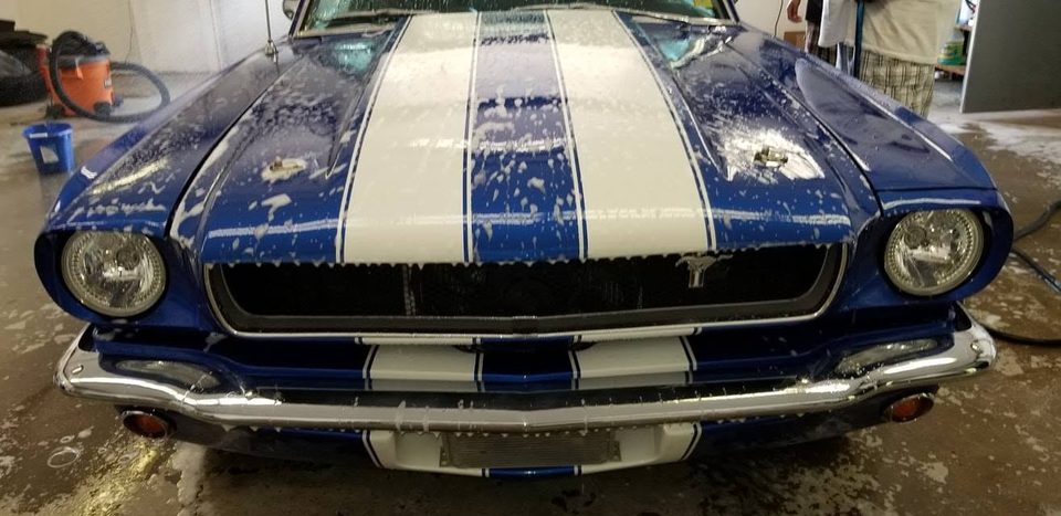 A 1966 Ford Mustang fastback in blue with white stripes, in for bodywork