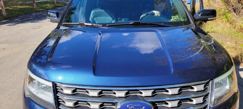 Paint correction results — mirror-gloss reflections down a detailed hood
